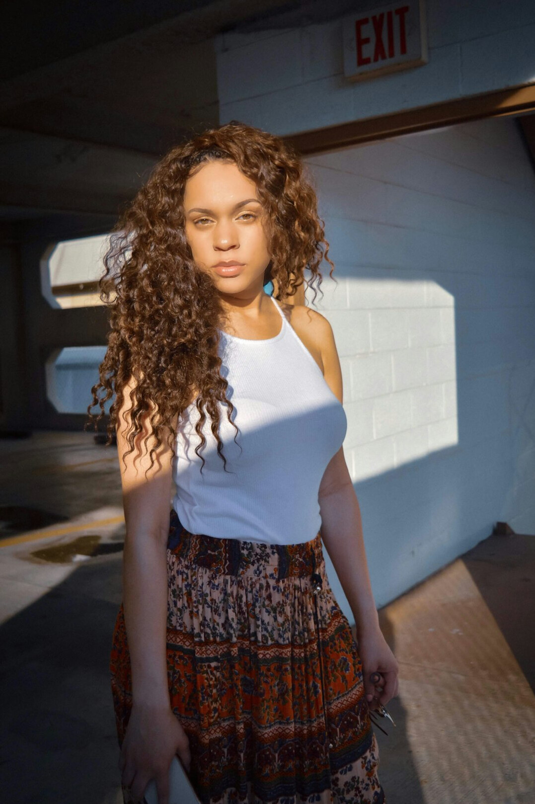 Portrait of a young woman in her late twenties with curly brown hair