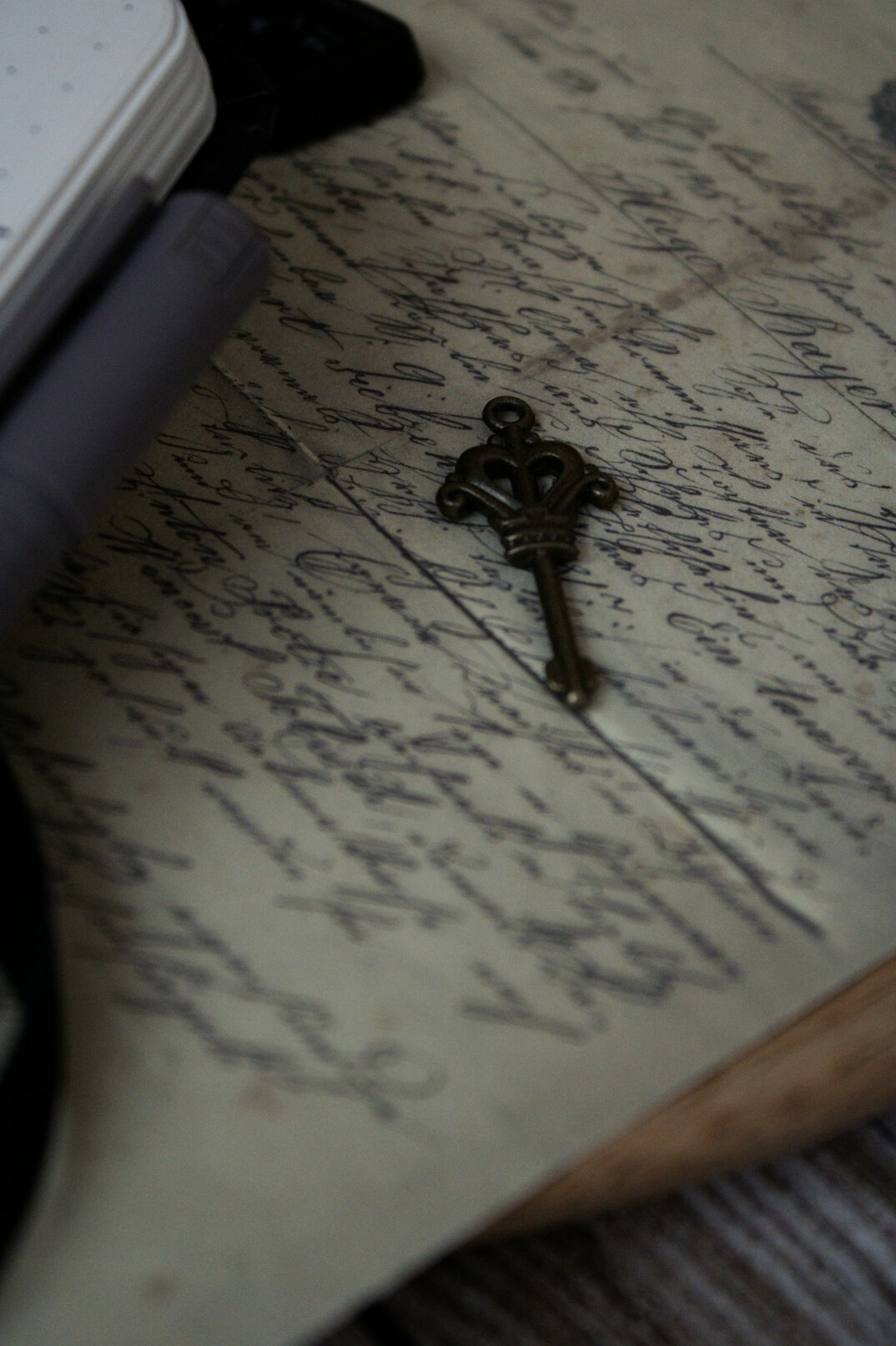 Antique brass key lying on an old handwritten letter